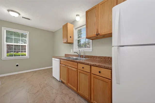 a kitchen with a refrigerator and white cabinets