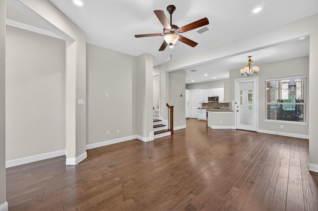 4224 Riverside Drive Flower Mound, TX 75028 - Photo 5 of 23 a view of a livingroom with a kitchen wooden floor and a ceiling fan