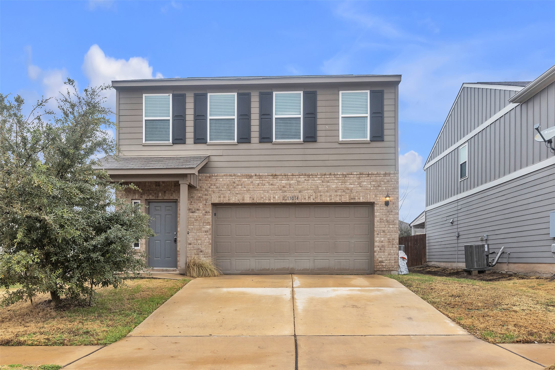 Traditional-style house featuring brick siding, an attached garage, and concrete driveway