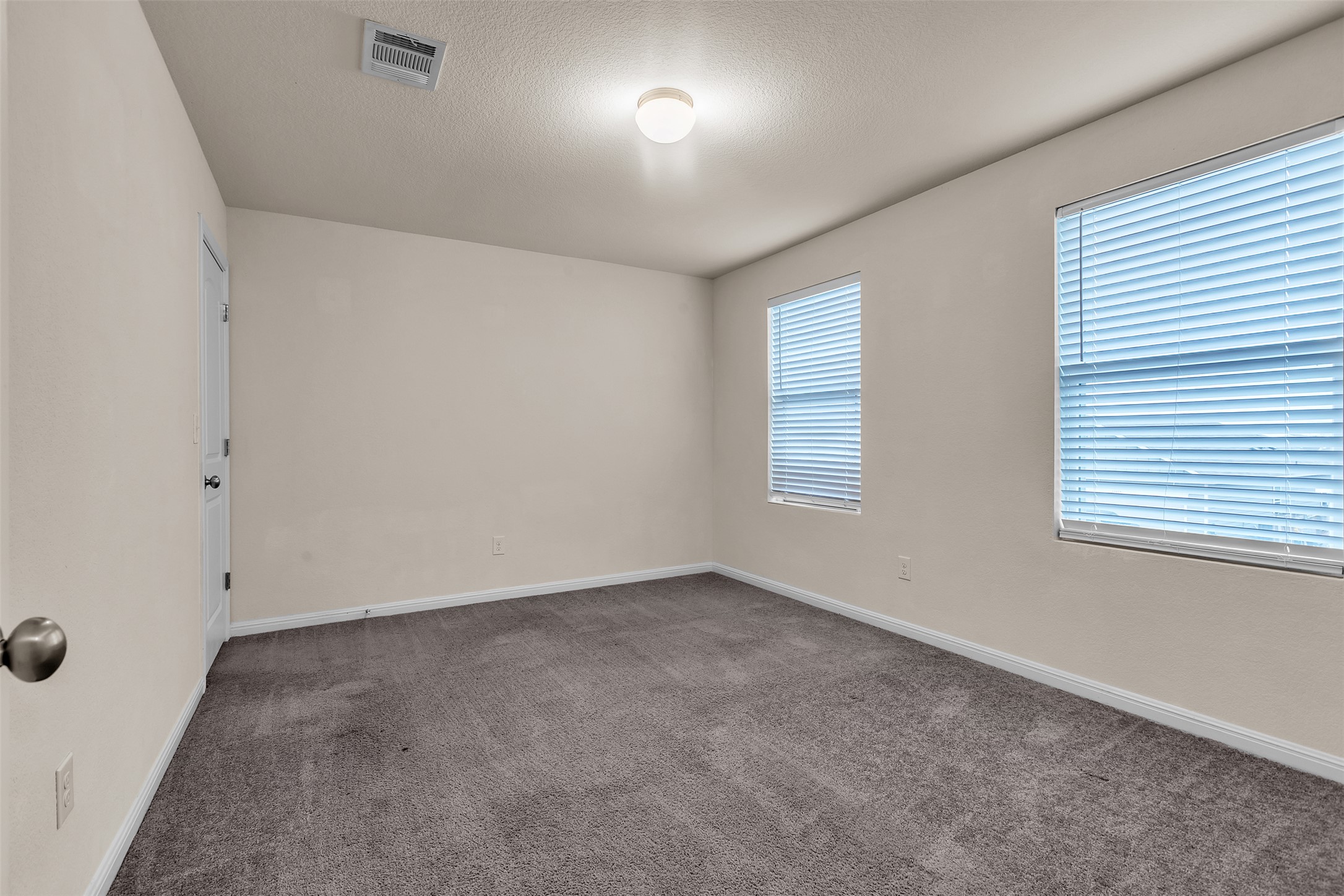 13014 Carswell Street Austin, TX 78754 - Photo 9 of 21 Carpeted spare room featuring a textured ceiling and baseboards