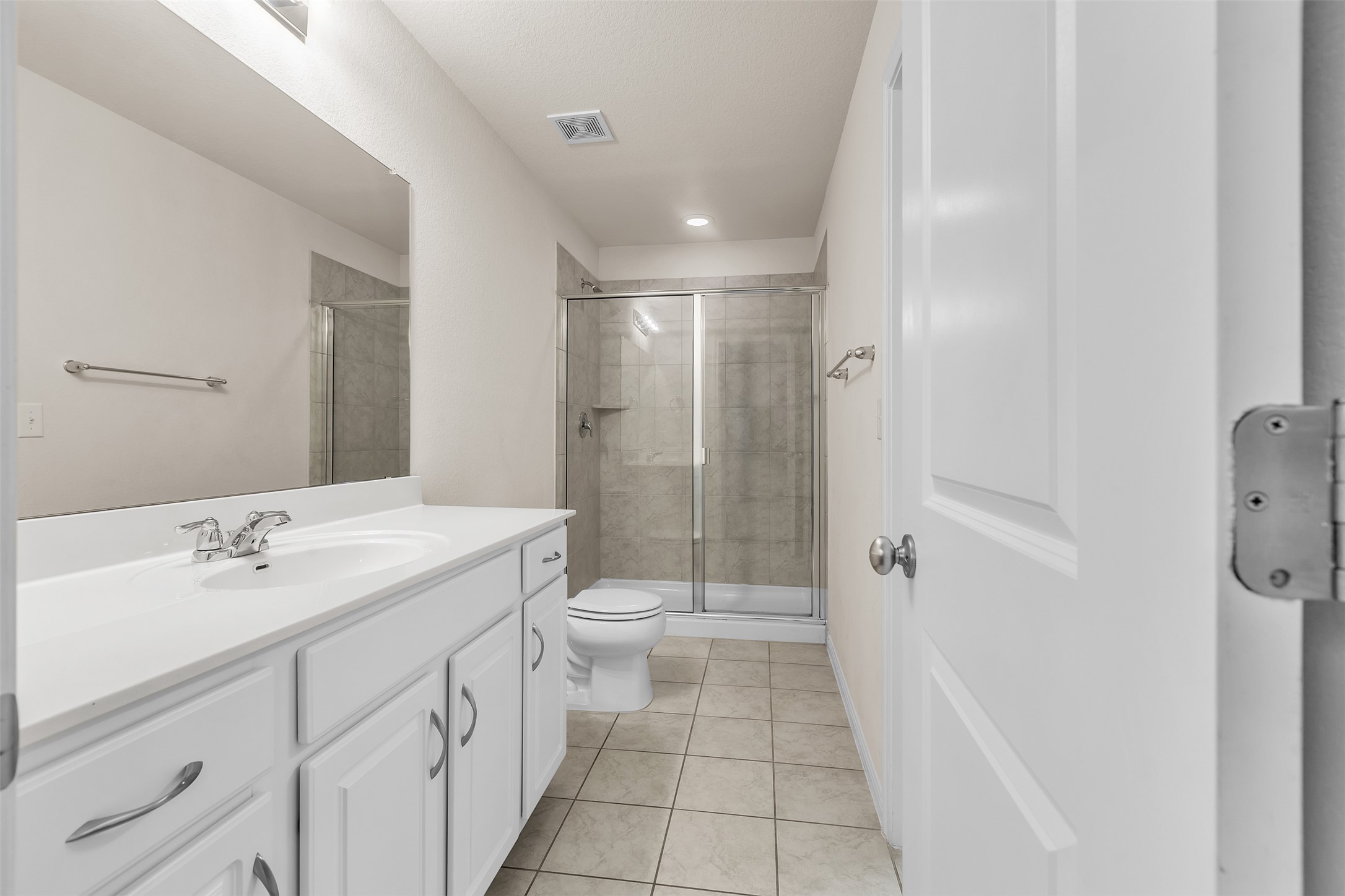 13014 Carswell Street Austin, TX 78754 - Photo 15 of 21 Bathroom featuring a stall shower, vanity, and light tile patterned floors