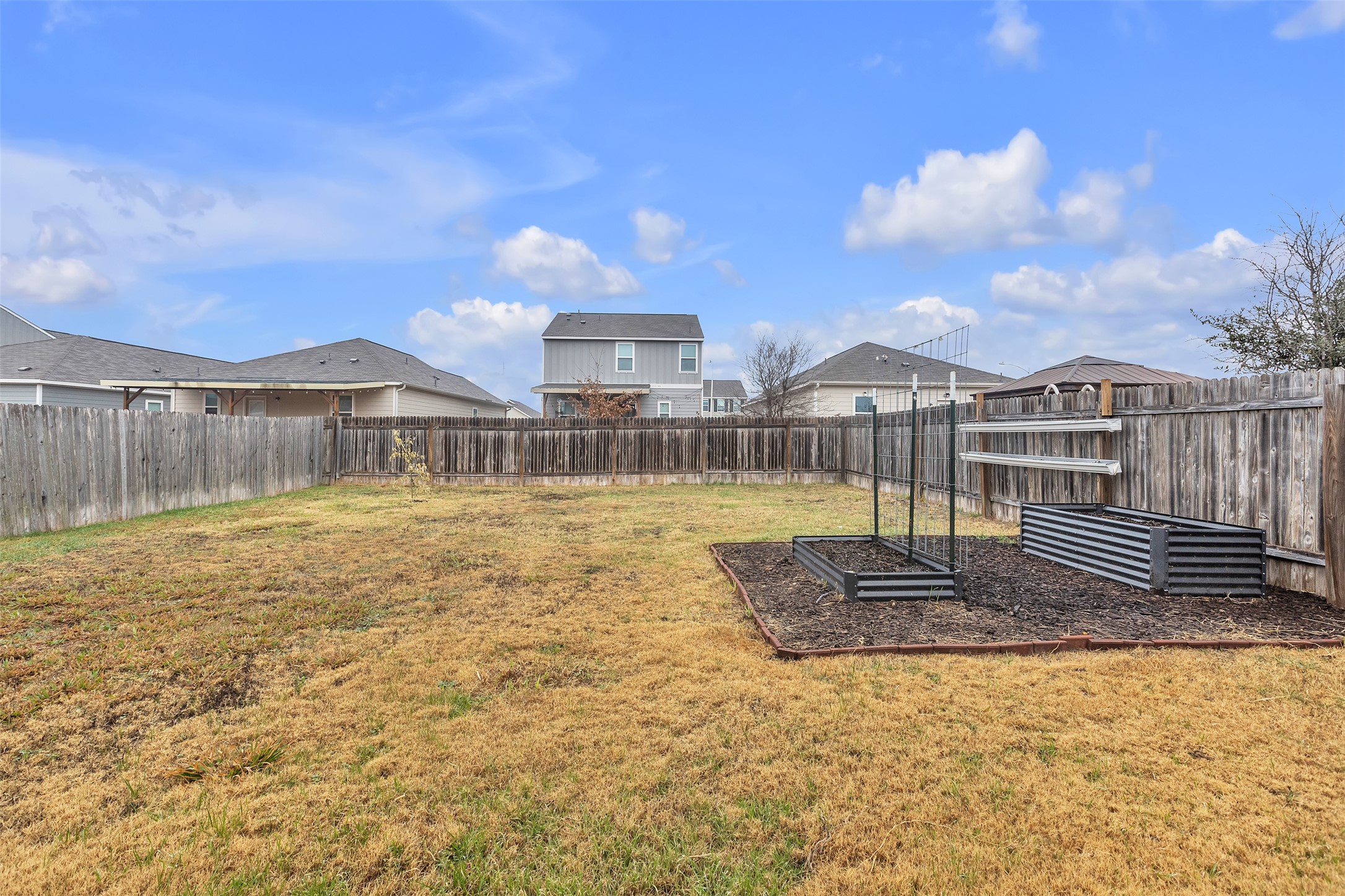 13014 Carswell Street Austin, TX 78754 - Photo 17 of 21 Fenced backyard with a vegetable garden and a residential view