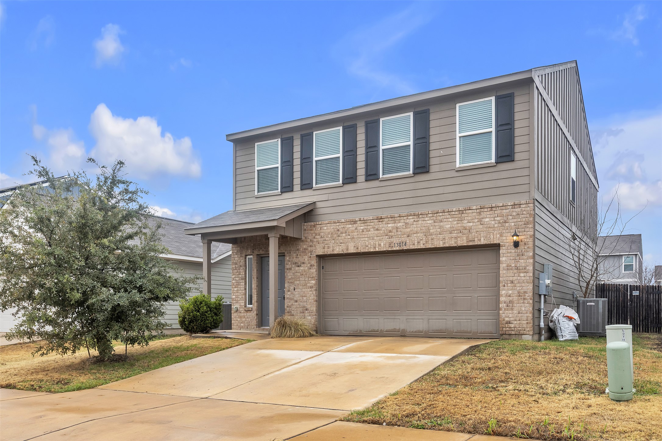 13014 Carswell Street Austin, TX 78754 - Photo 2 of 21 Traditional home featuring an attached garage, brick siding, and driveway