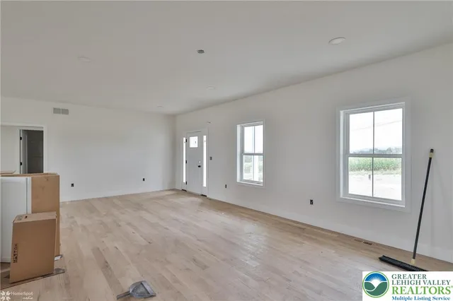 a view of a kitchen with refrigerator and wooden cabinets