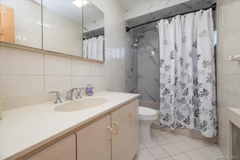 a bathroom with a sink a toilet and shower curtain