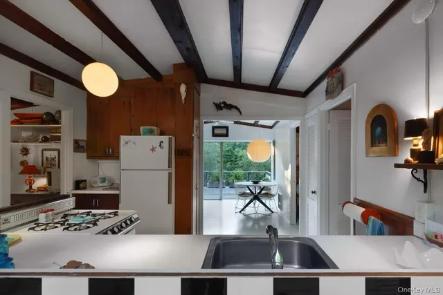 a view of kitchen island with furniture and refrigerator