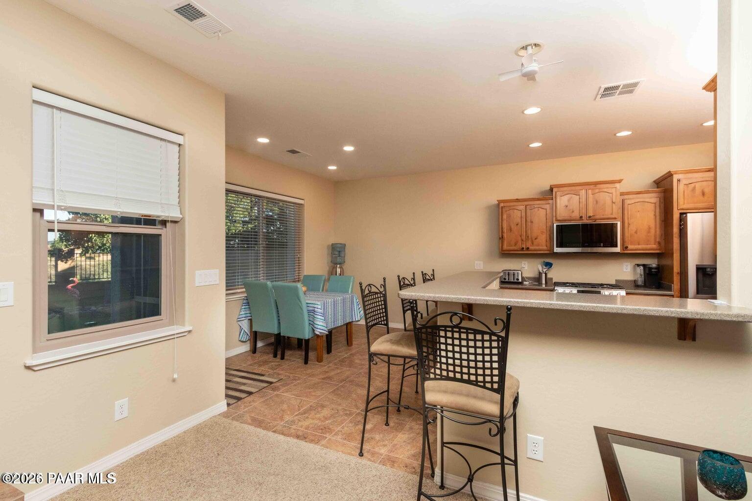 12933 Ponce Street Dewey, AZ 86327 - Photo 8 of 41 a kitchen with stainless steel appliances granite countertop a stove top oven a sink a dining table and chairs with wooden floor