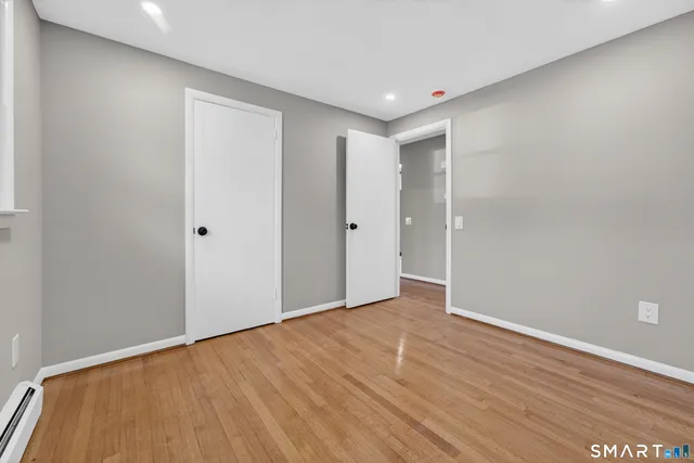 a view of an empty room with wooden floor