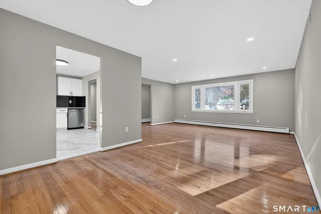 a view of empty room with wooden floor