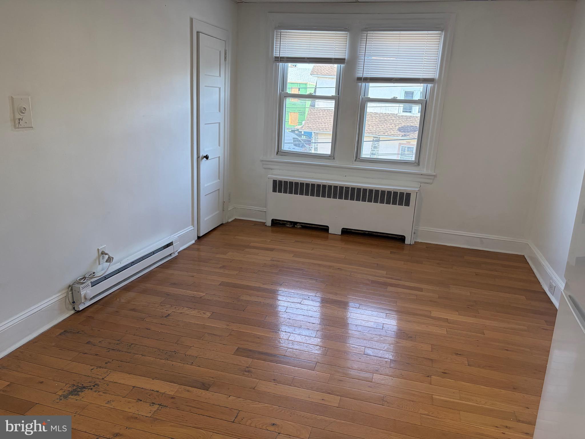 8 Overhill Road, Unit D Upper Darby, PA 19082 - Photo 2 of 5 an empty room with wooden floor and windows