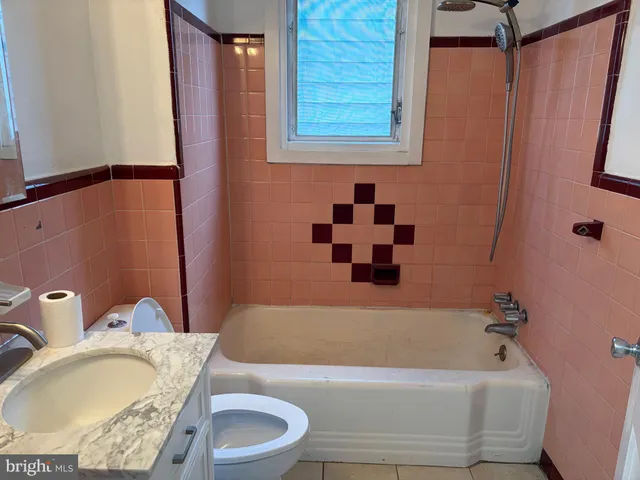 a bathroom with a granite countertop sink and a bathtub