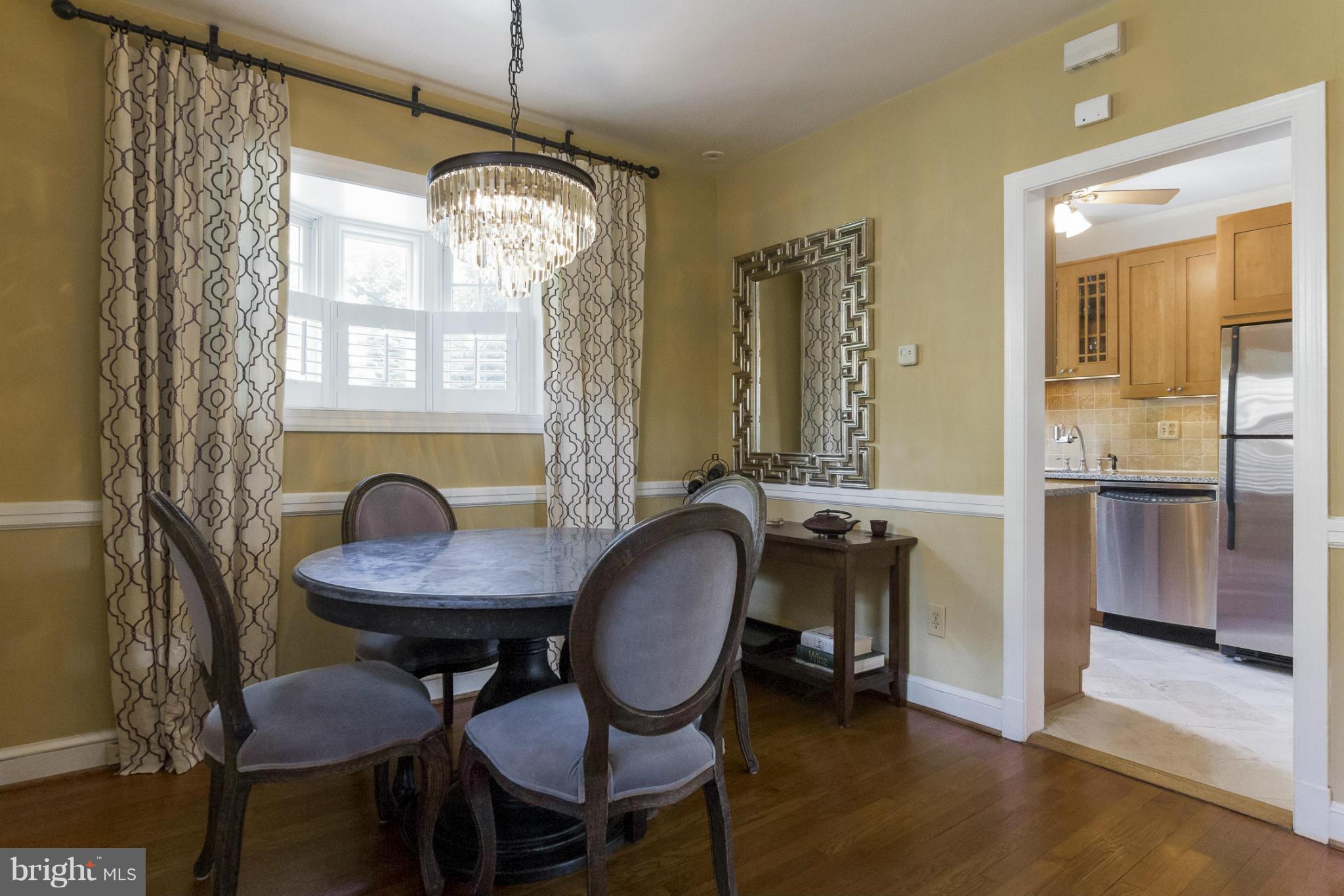 9921 Rogart Road Silver Spring, MD 20901 - Photo 6 of 30 a view of a dining room with furniture window and wooden floor