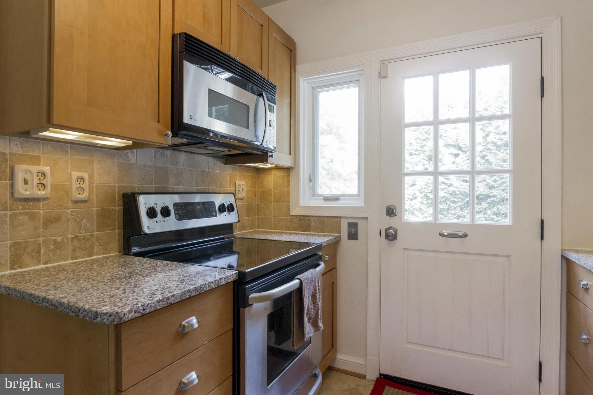 9921 Rogart Road Silver Spring, MD 20901 - Photo 9 of 30 a kitchen with stainless steel appliances granite countertop a stove microwave and sink