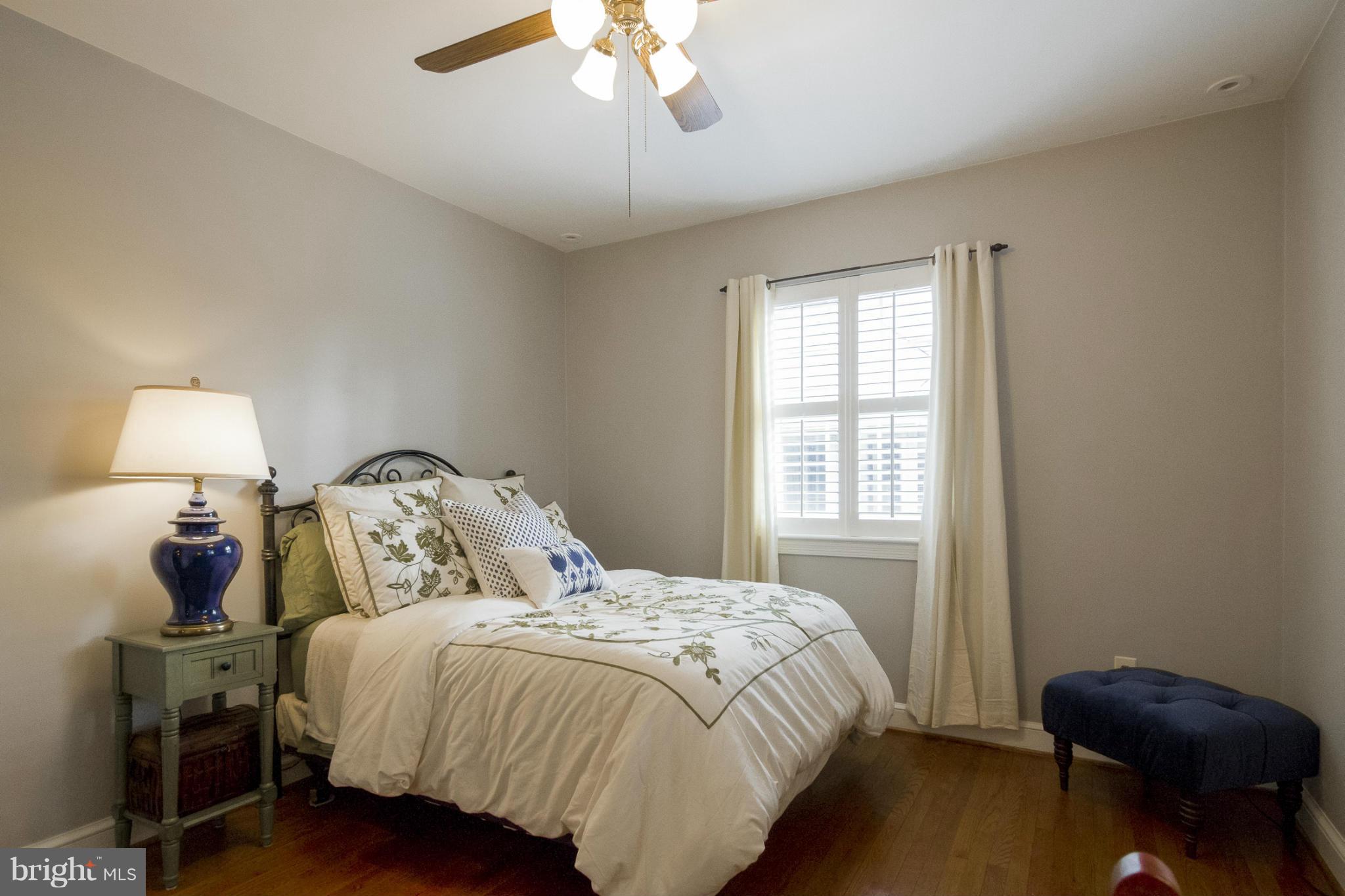 9921 Rogart Road Silver Spring, MD 20901 - Photo 10 of 30 a bedroom with a bed and a chair