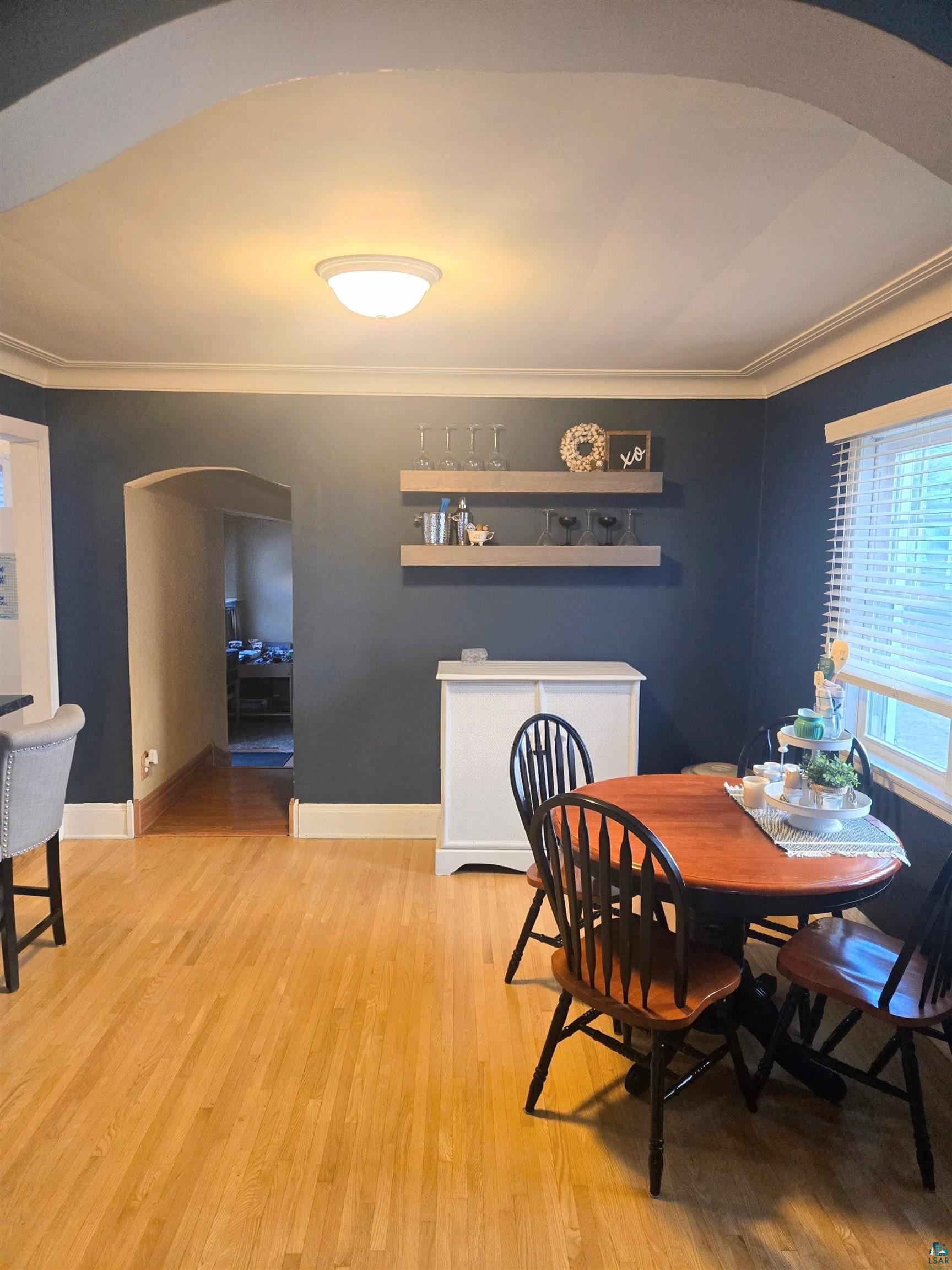 4327 West 5th Street Duluth, MN 55807 - Photo 13 of 25 Dining space featuring arched walkways, light wood-style flooring, plenty of natural light, and crown molding