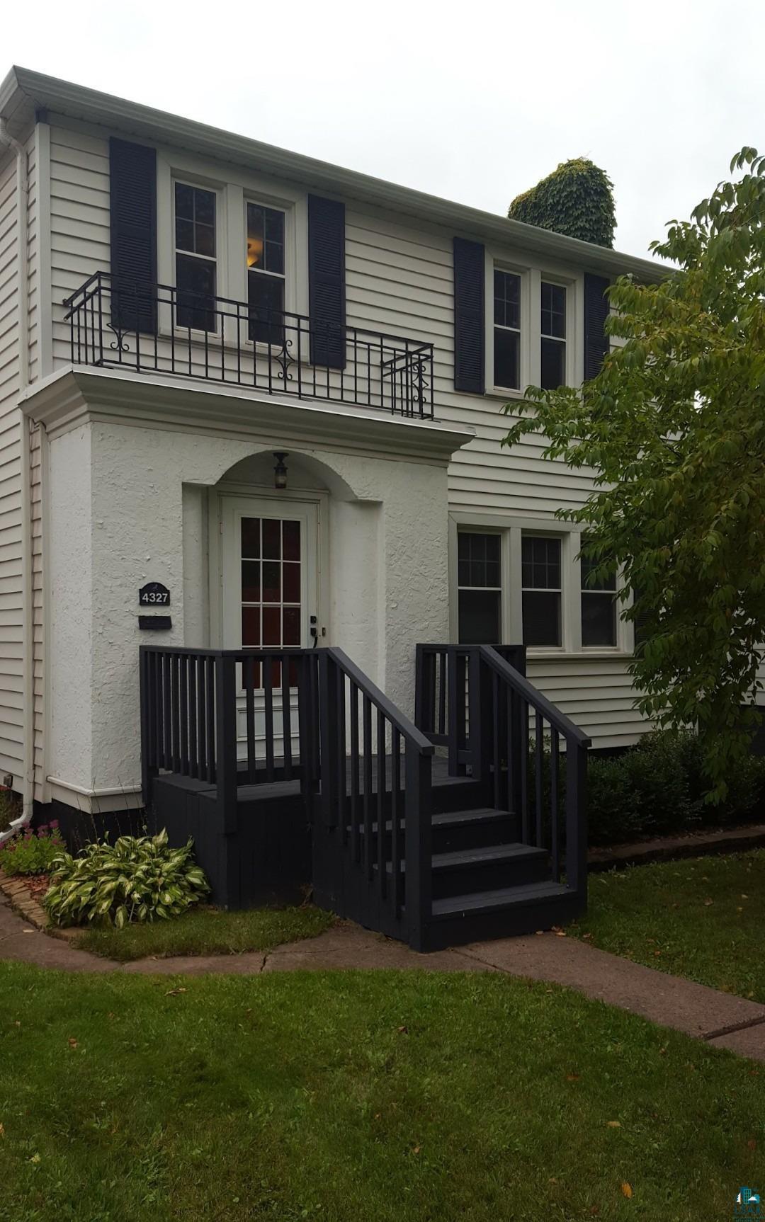 4327 West 5th Street Duluth, MN 55807 - Photo 3 of 25 View of front of house with a balcony, a front lawn, and stucco siding