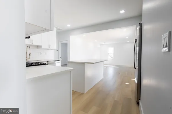 a view of a kitchen with a sink and dishwasher a refrigerator with wooden floor