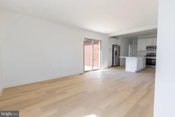 an empty room with a fireplace and windows