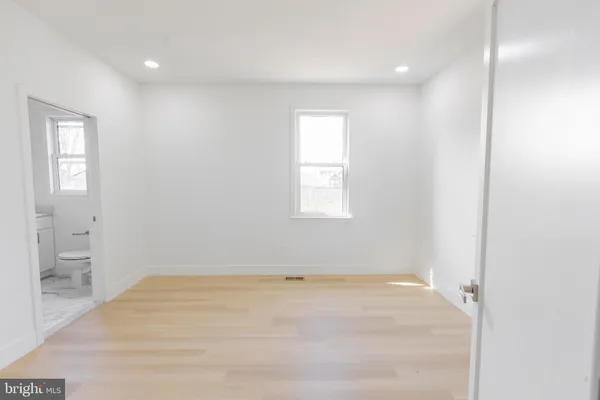 an empty room with windows and bathroom