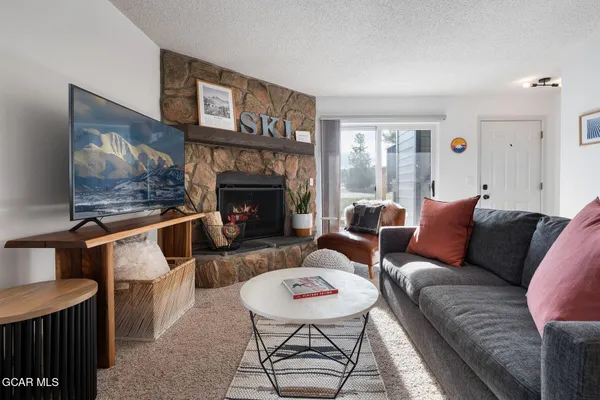 a living room with furniture a flat screen tv and a fireplace