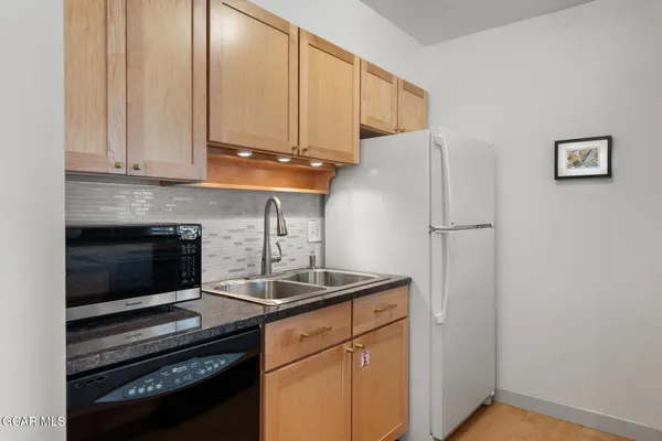 a kitchen with stainless steel appliances granite countertop a stove a refrigerator and a microwave