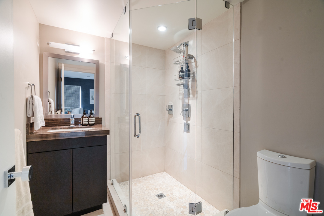 9318 Warbler Way Los Angeles, CA 90069 - Photo 19 of 46 a bathroom with a double vanity sink a toilet and shower
