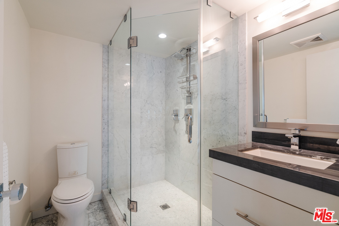 9318 Warbler Way Los Angeles, CA 90069 - Photo 22 of 46 a bathroom with a shower sink vanity mirror and toilet