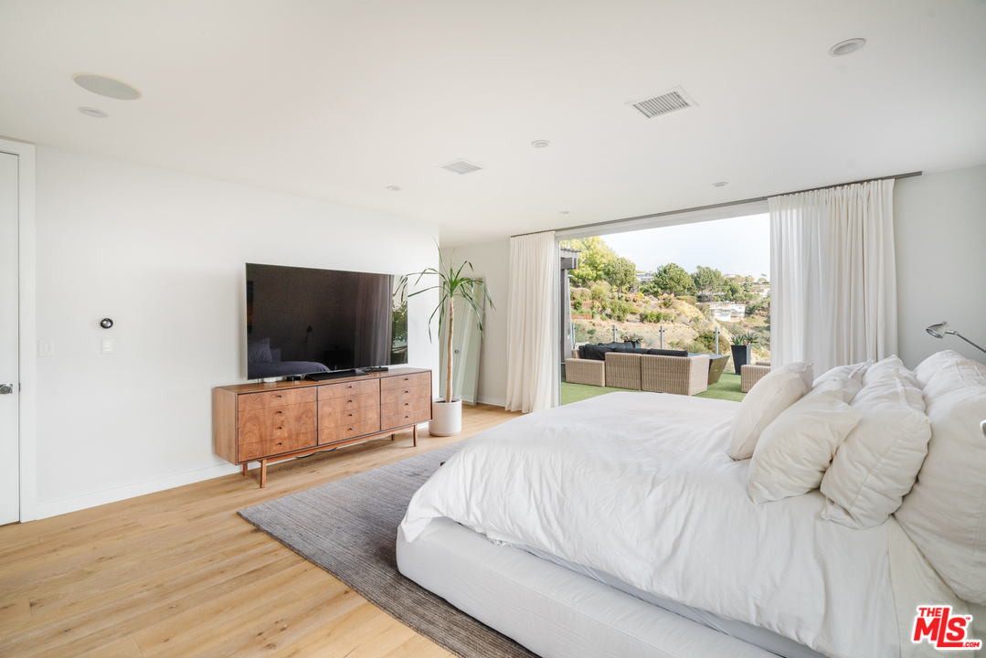 9318 Warbler Way Los Angeles, CA 90069 - Photo 27 of 46 a bedroom with a bed and a flat screen tv