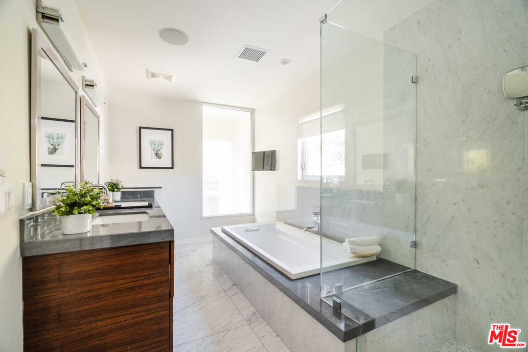 9318 Warbler Way Los Angeles, CA 90069 - Photo 28 of 46 a spacious bathroom with a granite countertop sink a toilet and shower