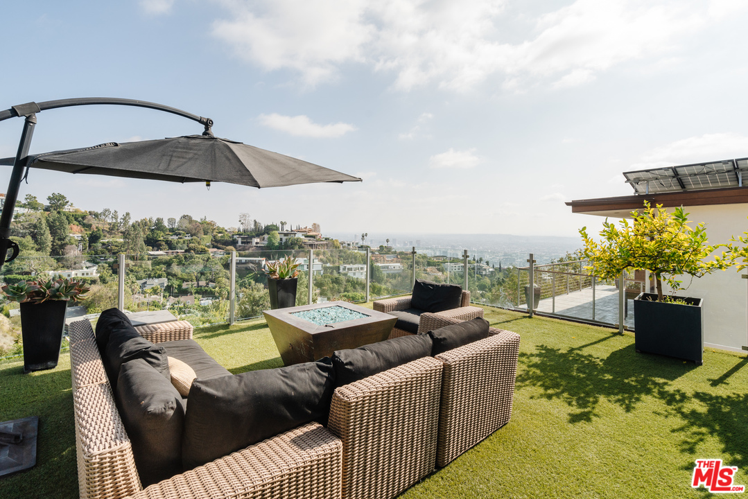 9318 Warbler Way Los Angeles, CA 90069 - Photo 32 of 46 a view of a roof deck with couches under an umbrella