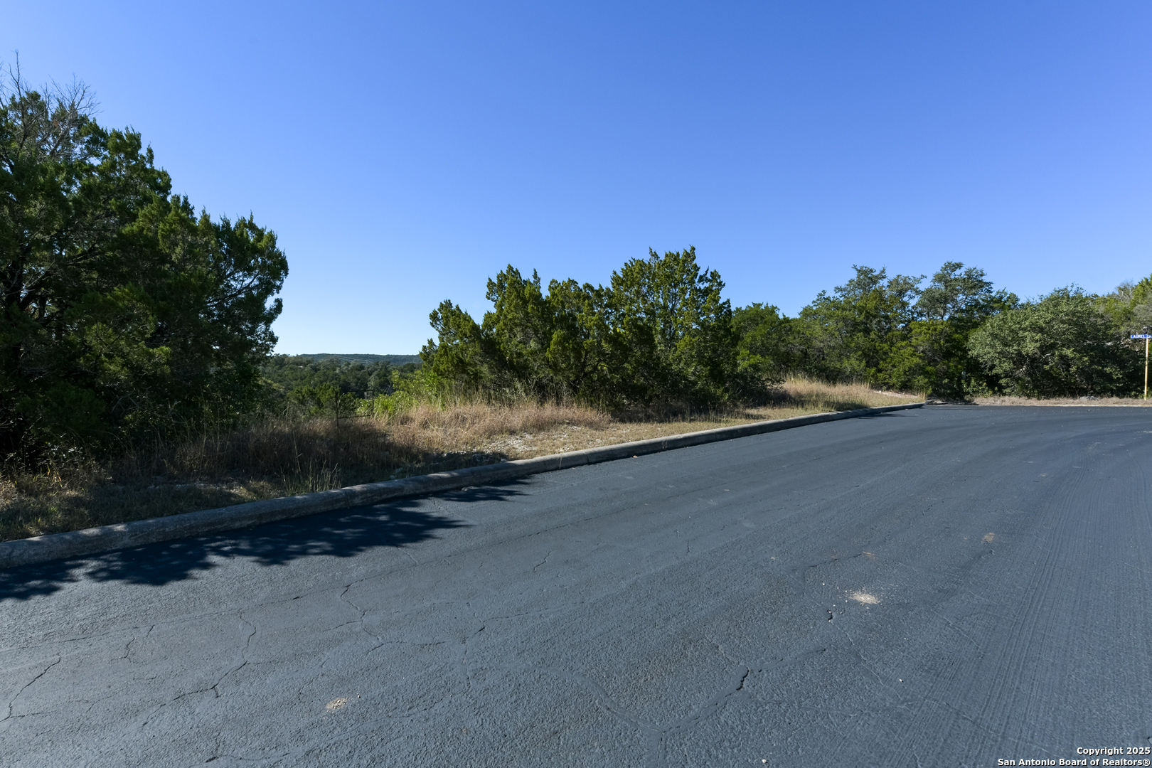 11304 Condor Pass Helotes, TX 78023 - Photo 6 of 6 a view of a road with a yard