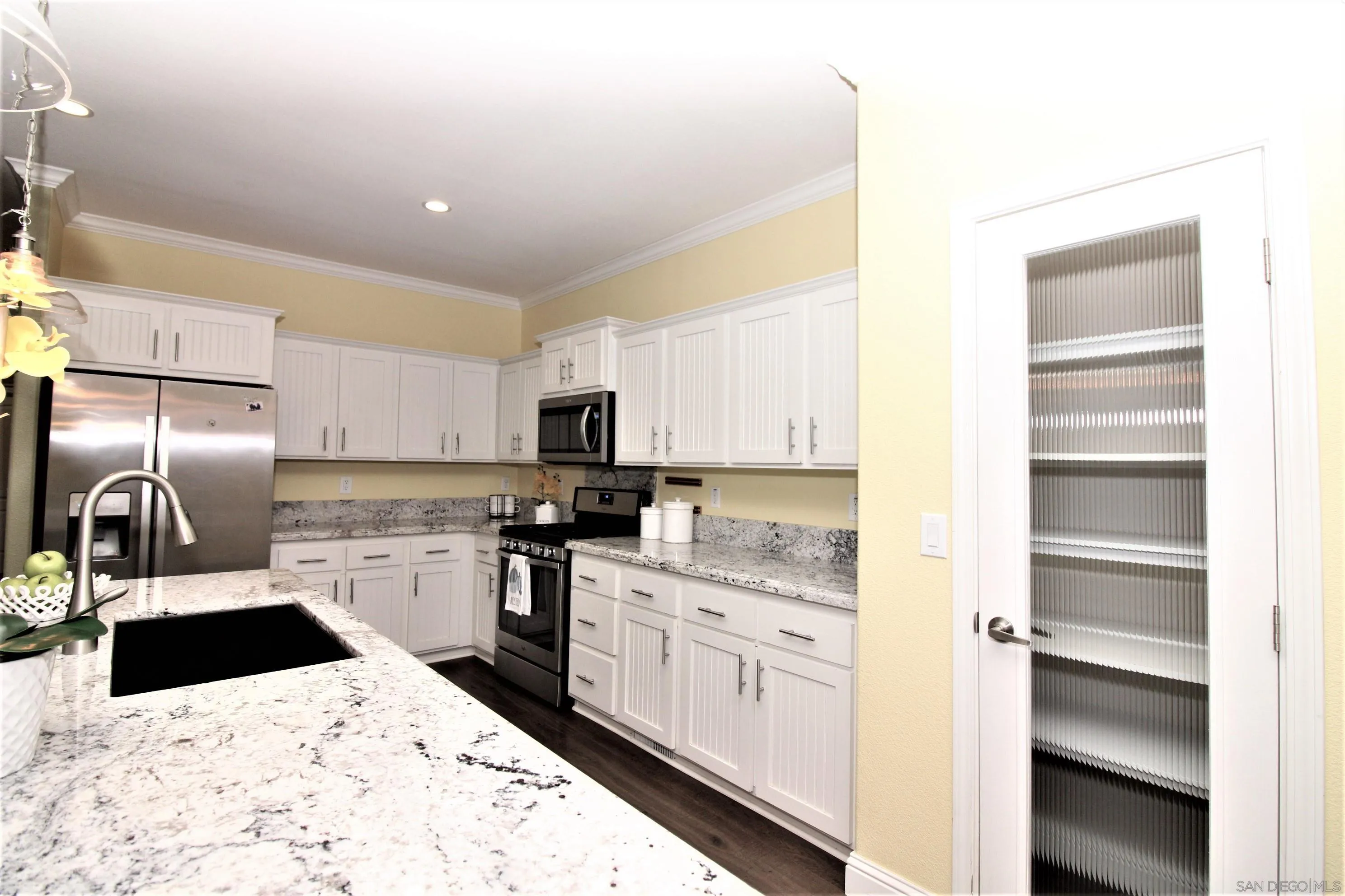 7132 Santa Rosa Carlsbad, CA 92011 - Photo 5 of 54 a kitchen with stainless steel appliances kitchen island granite countertop a refrigerator and a sink