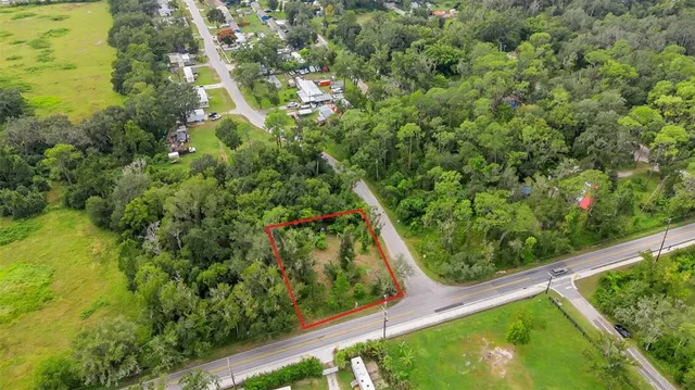 an aerial view of residential houses with outdoor space and trees