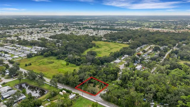 an aerial view of residential houses with outdoor space and trees all around