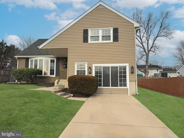 a front view of a house with a yard and potted plants