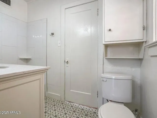a bathroom with a granite countertop toilet and a sink