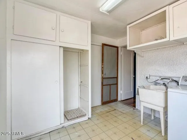 a room with a stove a sink and cabinets