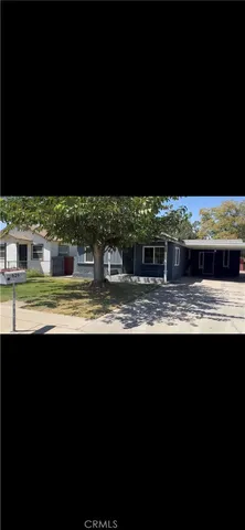 a view of house with swimming pool and a yard