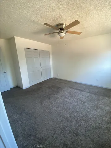 an empty room with a ceiling fan and a window
