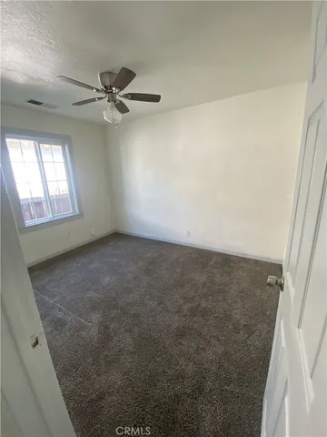 en empty room with windows and fan