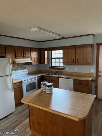 a living room with stainless steel appliances granite countertop furniture wooden floor and a window