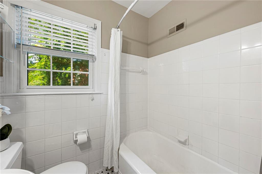 542 Goldsboro Road Northeast, Unit D Atlanta, GA 30307 - Photo 14 of 26 a bath room with a toilet a bath tub and a window