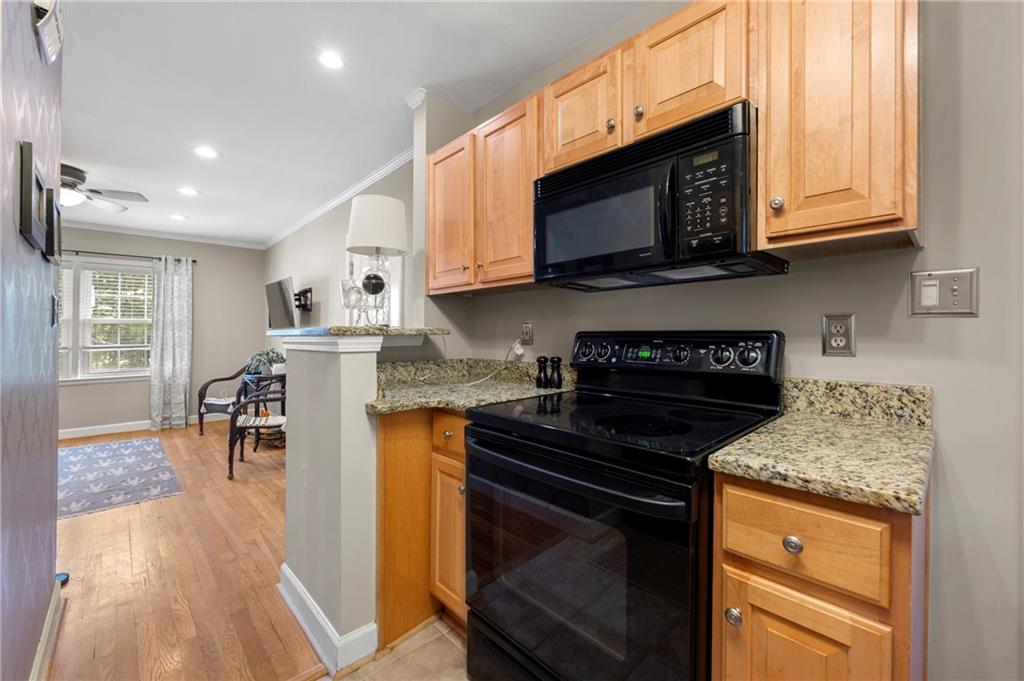 542 Goldsboro Road Northeast, Unit D Atlanta, GA 30307 - Photo 9 of 26 a kitchen with granite countertop wooden cabinets and a stove top oven