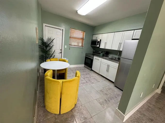 a kitchen with stainless steel appliances a stove a sink a microwave a refrigerator and cabinets