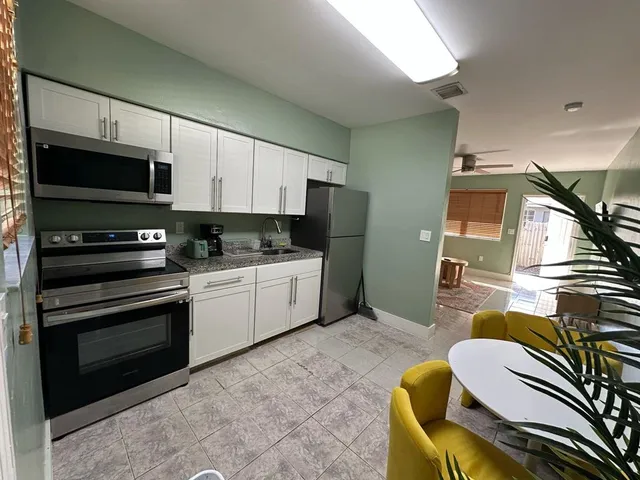 a kitchen with a refrigerator and a stove top oven