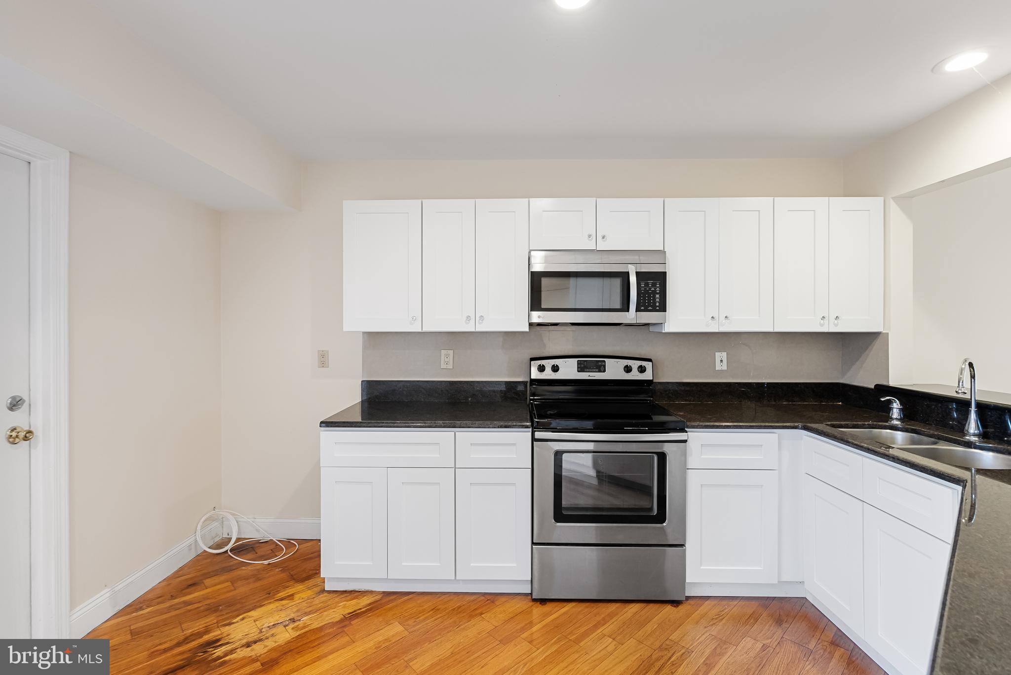 962 Chanticleer Cherry Hill, NJ 08003 - Photo 18 of 38 a kitchen with stainless steel appliances granite countertop a stove a microwave and a white cabinets