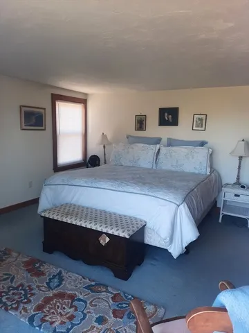 a bedroom with a bed couch and a window