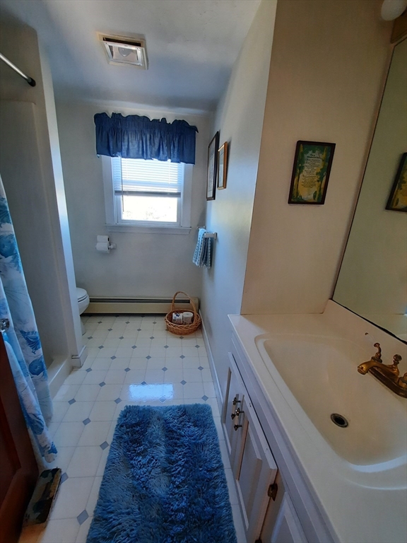 21 Manchester Street, Unit 21 Scituate, MA 02066 - Photo 6 of 11 a bathroom with a sink a toilet a window and vanity