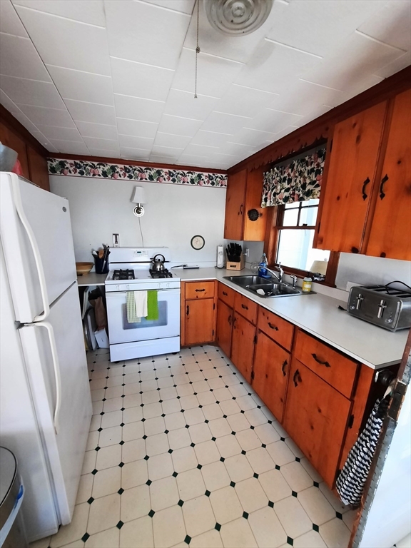 21 Manchester Street, Unit 21 Scituate, MA 02066 - Photo 7 of 11 a kitchen with stainless steel appliances a stove a sink and a refrigerator