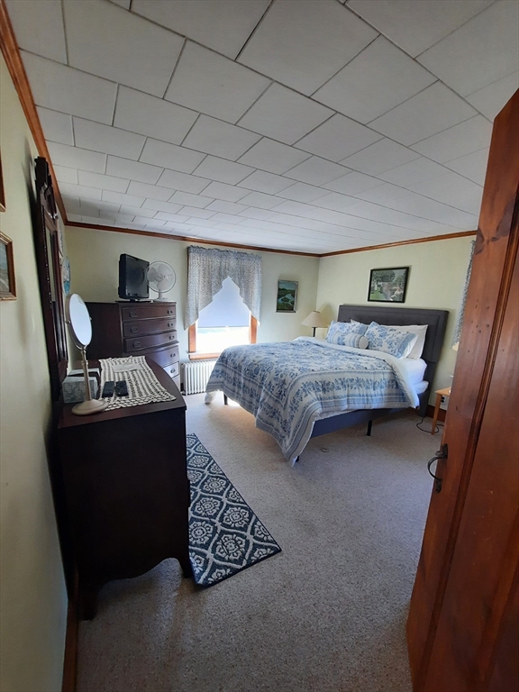 21 Manchester Street, Unit 21 Scituate, MA 02066 - Photo 9 of 11 a bedroom with a bed and a mirror